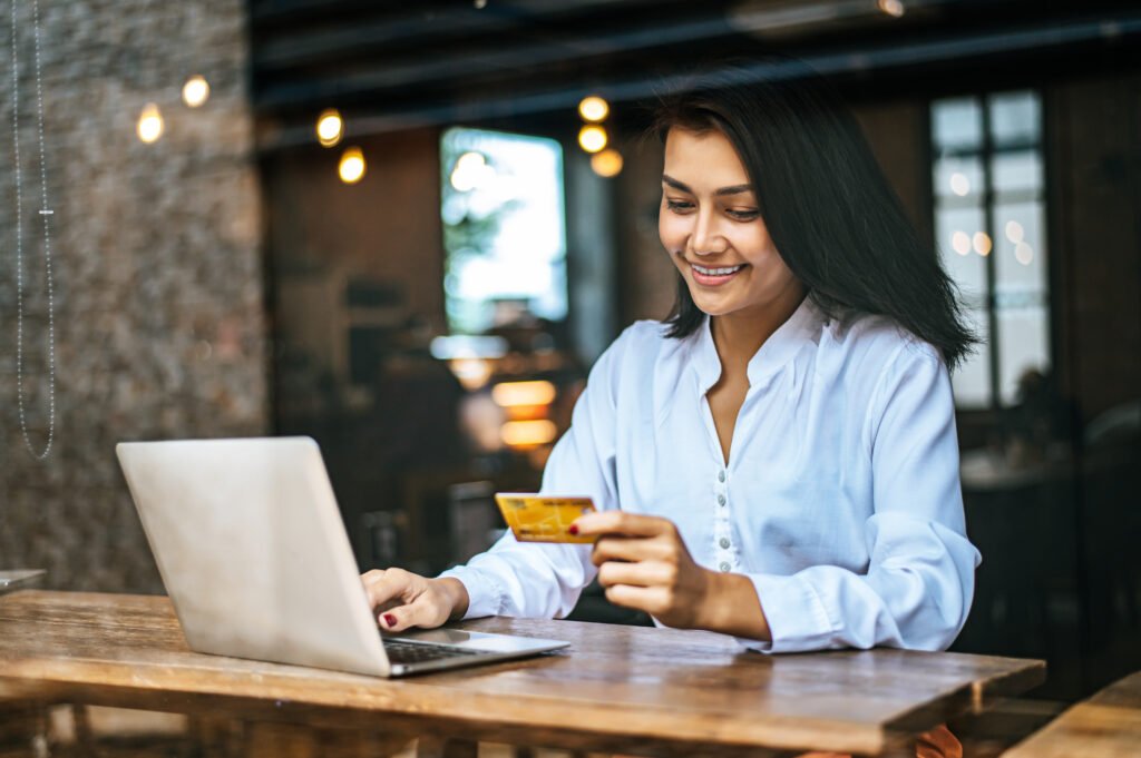 woman sat with a laptop and paid with a credit card in a coffee woman sat with a laptop and paid with a credit card in a coffee